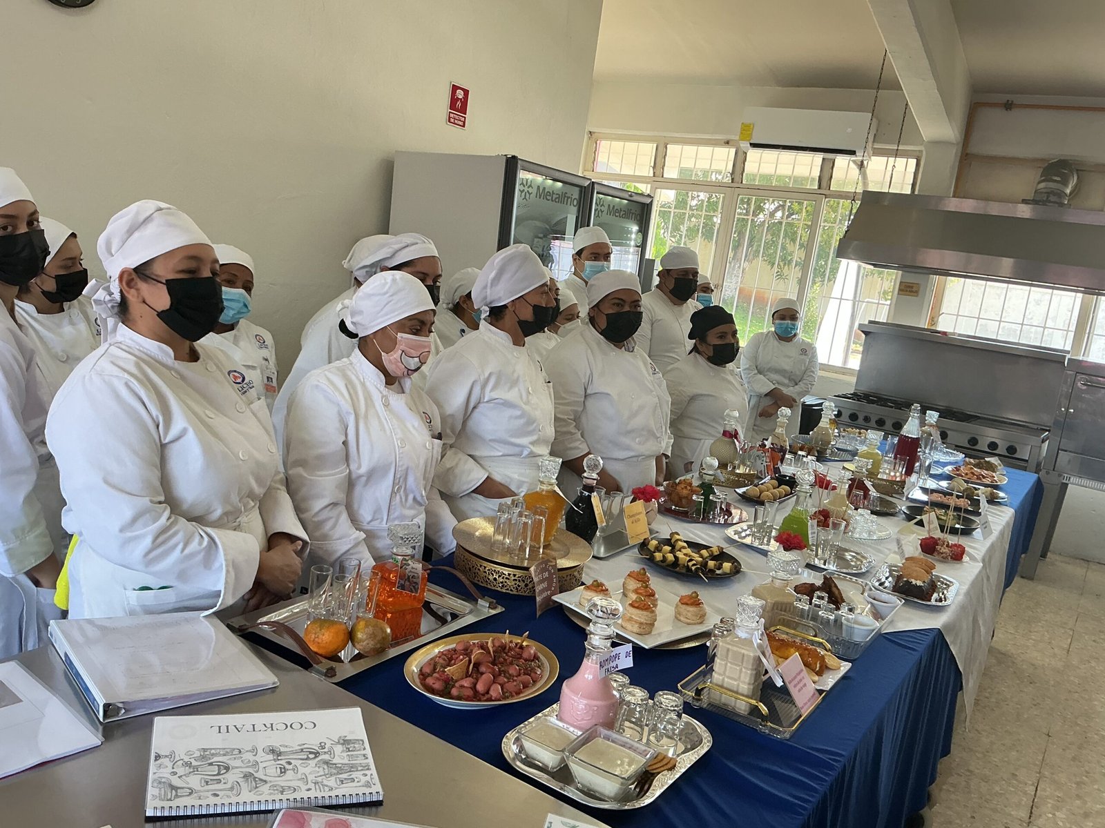 Estudiantes realizando prácticas culinarias en cocina profesional