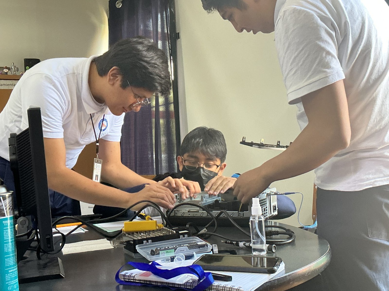 Estudiantes trabajan con componentes internos de una computadora